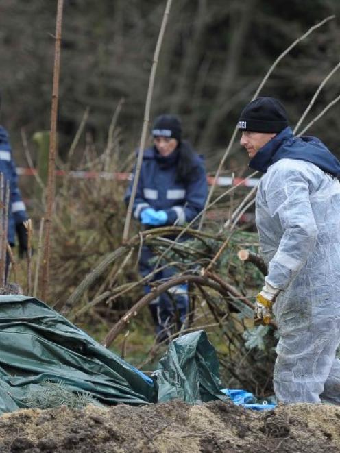 Police experts inspect the scene where a body was found at the bed and breakfast establishment of...