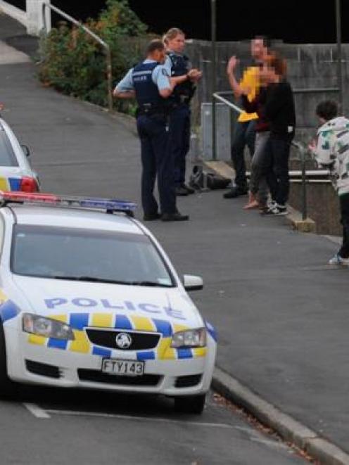 Police interview people at the scene on Filleul St yesterday after an earlier racist incident in...