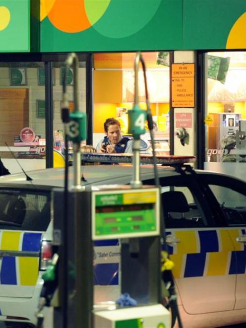 Police investigate after a petrol station was robbed last night. Photo by Stephen Jaqiery.