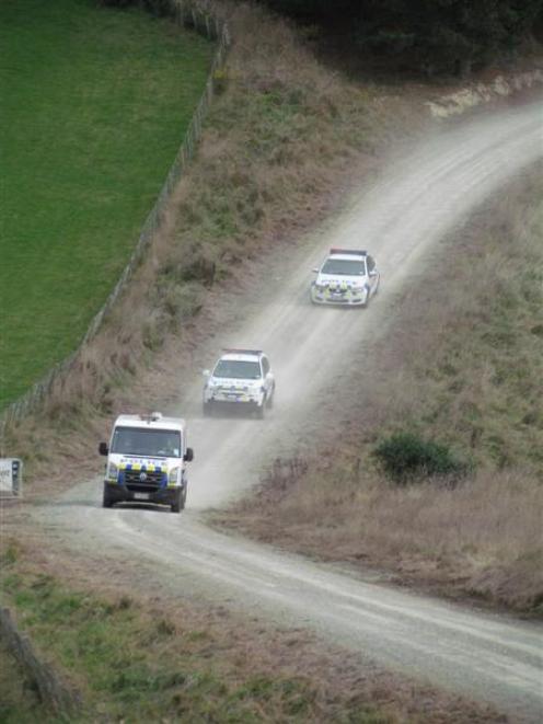 Police leave the scene of an exhaustive manhunt in Waianakarua yesterday.