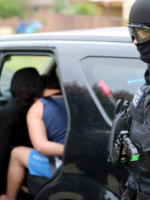 Police officers detain a man during early morning raids in western Sydney today. REUTERS/NSW Police
