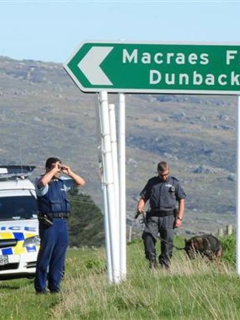 Police officers search for three teenagers near Hyde yesterday. Photo by Craig Baxter.
