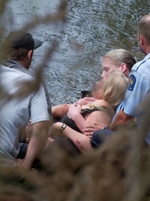Police officers with the woman after she was taken to shore. Photo / Christine Cornege