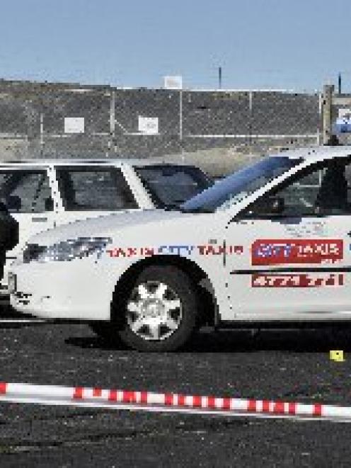 Police search the scene of Saturday night's assault and robbery of a taxi driver in Moana Rua Rd,...