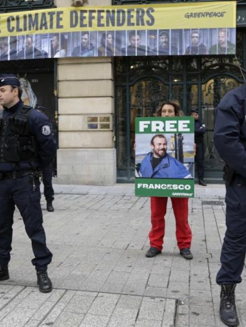 Police secure the area as Greenpeace activists protest in front of Gazprom headquarters in Paris....