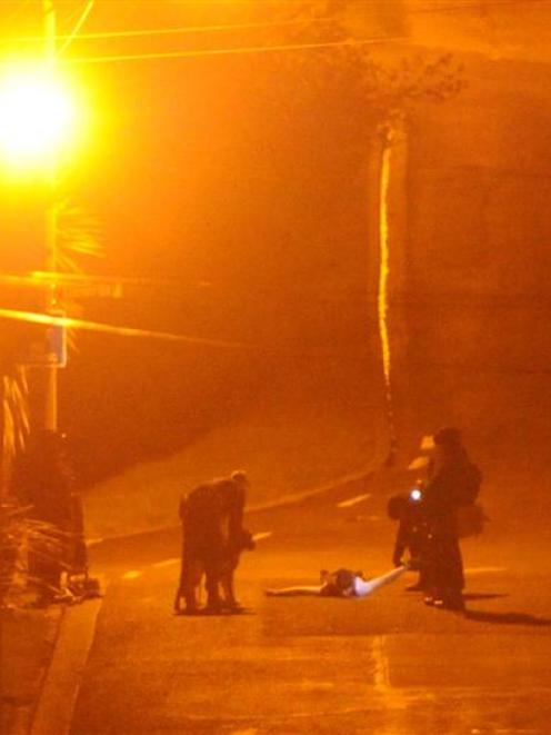 Police take a man into custody last night. Photo by Craig Baxter.