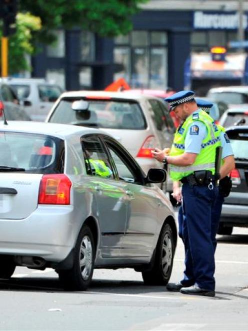 Police talk to a driver during an operation in Crawford St, Dunedin, yesterday. Photo by Linda...