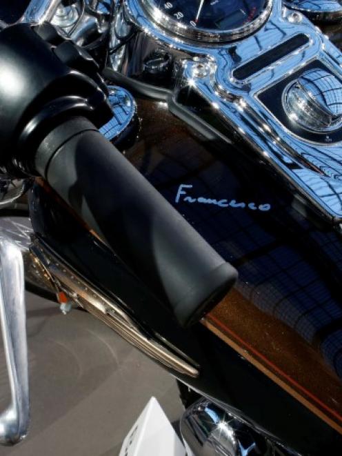Pope Francis' signature is seen on the tank of his Harley Davidson Dyna Super Glide before its...