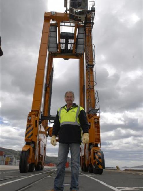 Port Otago cargo handler Harry Harrington is dwarfed by a 14m-tall Kalmar straddle crane recently...