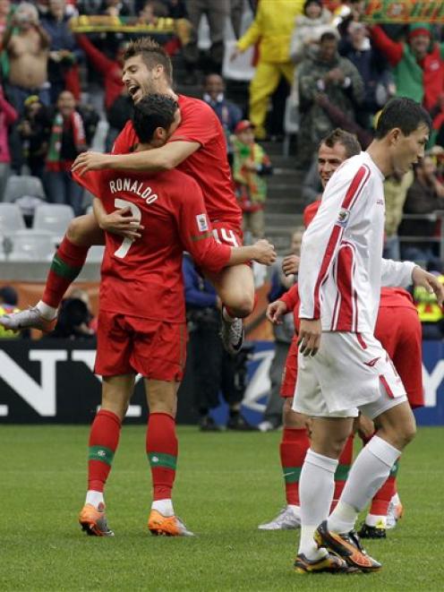 Portugal's Cristiano Ronaldo, left, and Miguel Veloso, back left, celebrate their 7-0 win. (AP...