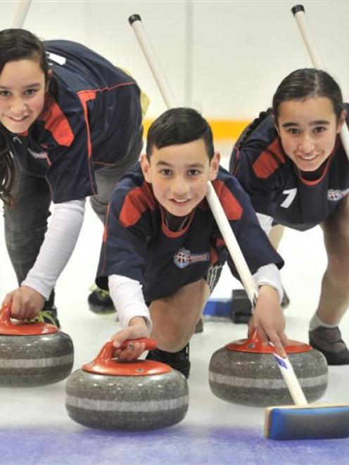 Practising their curling at the Dunedin Ice Stadium are (from left) Temika (12),  Jayden (11) and...