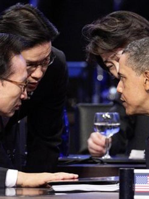 President Barack Obama talks with South Korean President Lee Myung-bak, left, during the opening...