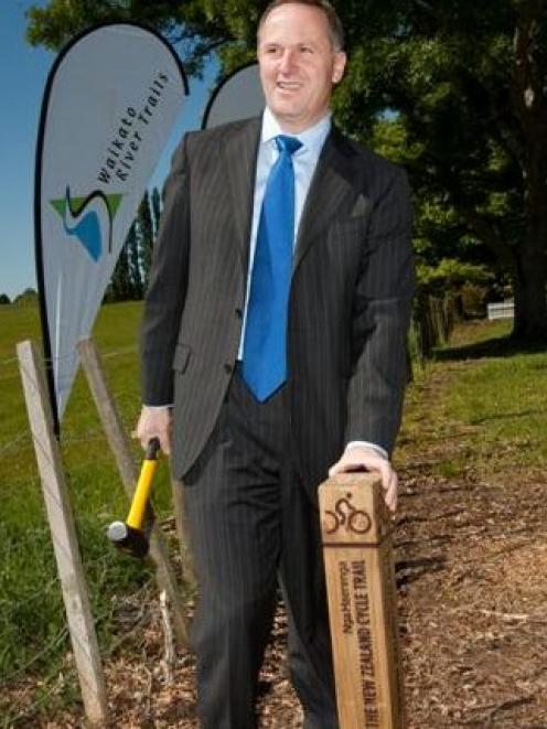 Prime Minister John Key hammers in a post to launch the construction of the New Zealand Cycle...