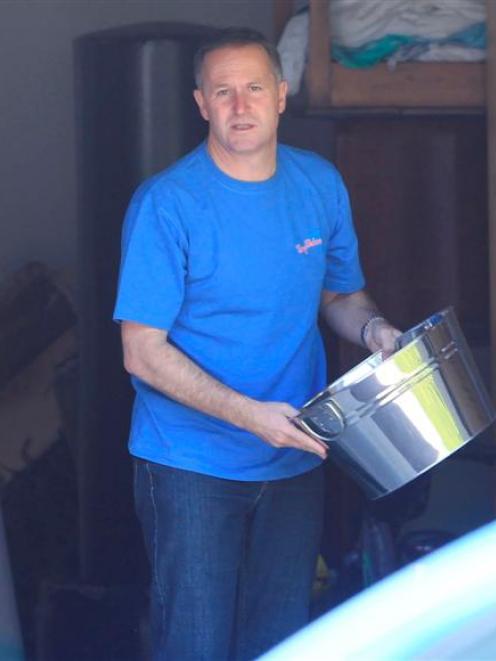 Prime Minister John Key sorts through his garage yesterday ahead of entertaining guests after...