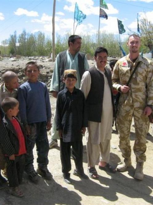 Private Geoff White with Afghan civilians near his base in Bamiyan province. Photo supplied.
