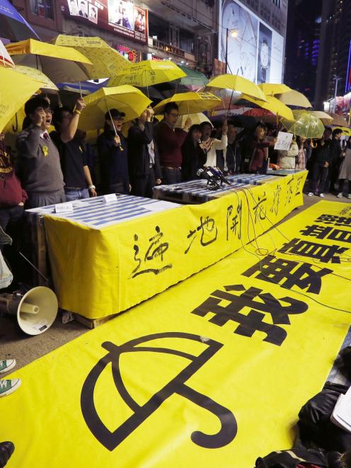Pro-democracy protesters carrying umbrellas, symbol of the Occupy Central civil disobedience...