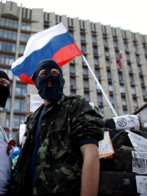 Pro-Russia protesters stand guard near a barricade outside a regional government building in...