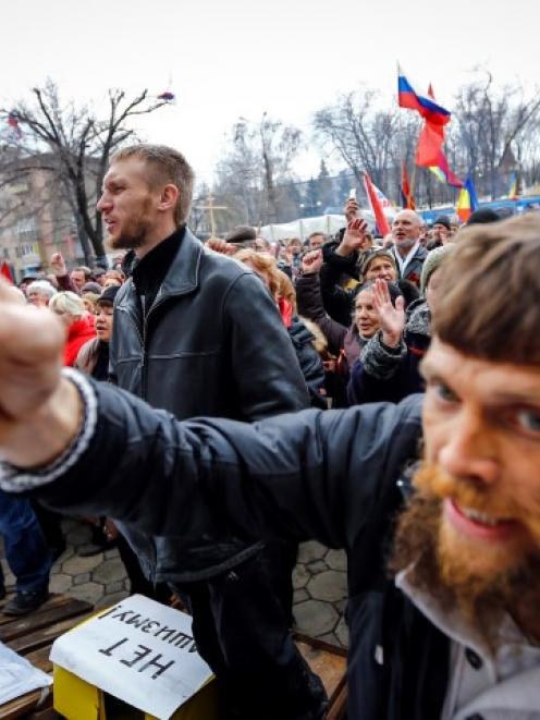 Pro-Russian protesters attend a rally in front of the seized office of the SBU state security...