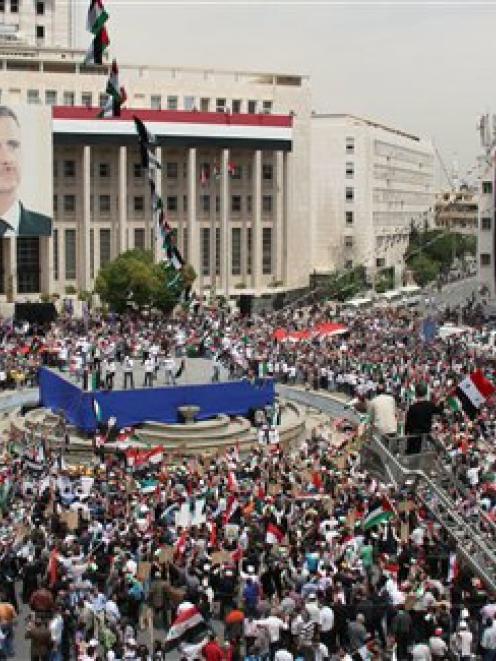 Pro-Syrian government demonstrators hold a rally at Sabe Bahrat Square to commemorate the 65th...