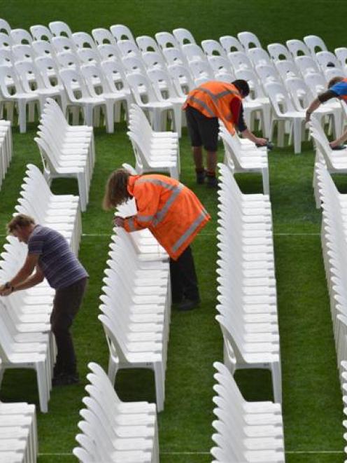 Production crew work at getting the stage and seating ready yesterday for Paul Simon's concert at...