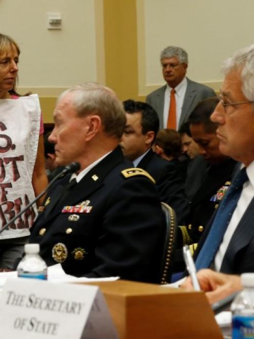 Protester Medea Benjamin is pictured alongside US General Martin Dempsey, chairman of the Joint...
