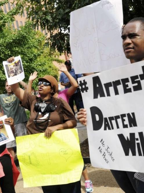 Protesters at the St. Louis County Justice Centre call for the arrest of Police Officer Darren...
