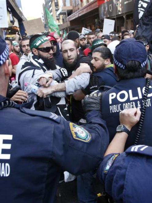 Protesters clash with police on a street in Sydney's central business district last Saturday. ...