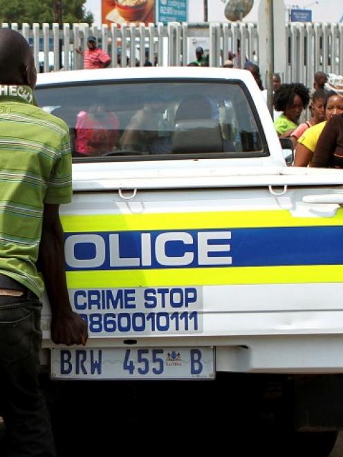 Protesters shout as a police vehicle drives into the Daveyton Police station east of Johannesburg...