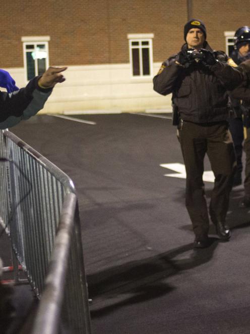 Protesters shout towards police as they demand the criminal indictment of a white police officer...