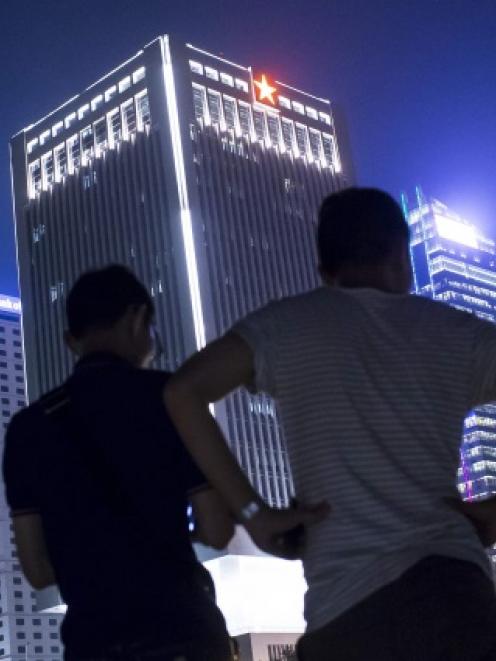 Protesters stand in front of the Chinese People's Liberation Army Forces Hong Kong building, as...