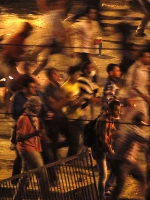 Protesters throw stones during a clash between supporters and opponents of ousted Egyptian...