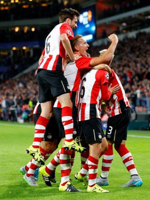 PSV Eindhoven players celebrate scoring a goal against Manchester United. Photo: Reuters.