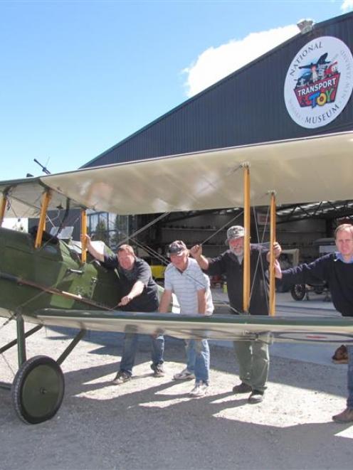 Pushing a 1970 replica SE5A plane out of a hangar at Wanaka's National Transport and Toy Museum...