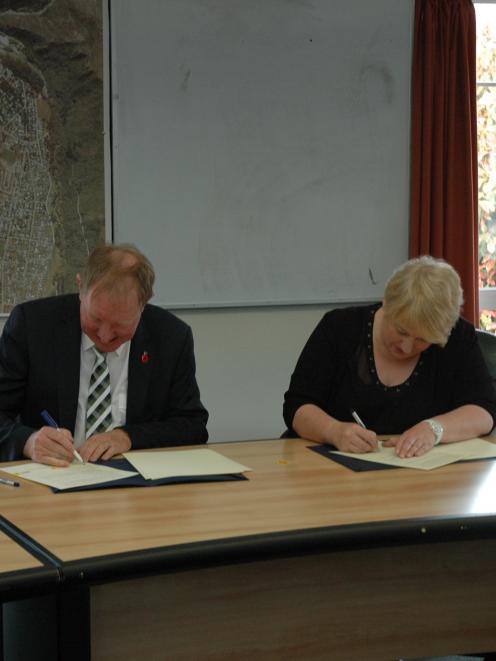 Housing Minister Nick Smith and Queenstown Lakes Mayor Vanessa van Uden sign the agreement...