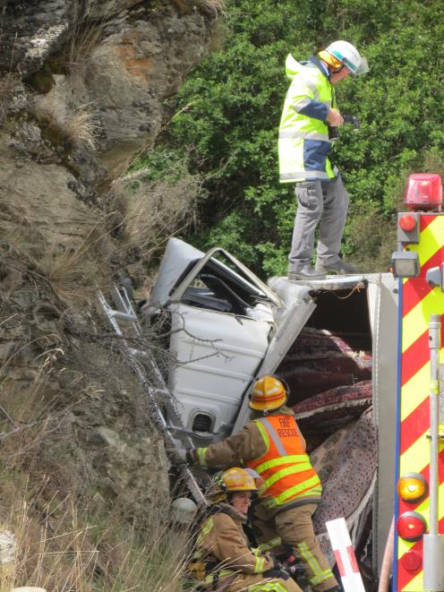 The truck, carrying a load of carpet, lies against a bank. Photos by Tracey Roxburgh.
