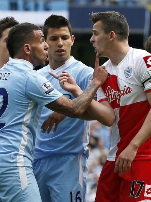 Queens Park Rangers' Joey Barton (R) confronts Manchester City's Carlos Tevez during their...