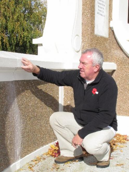 Queenstown RSA president David Geddes inspects one of the many cracks evident in the Queenstown...