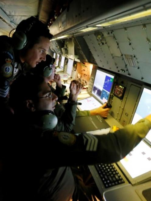 Radar specialists on board a Royal New Zealand Air Force P-3K2 Orion take part in the search for...