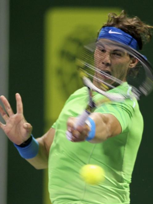 Rafael Nadal, of Spain, returns the ball to Mikhail Youzhny, of Russia, during their Qatar Open...