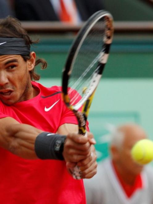 Rafael Nadal of Spain returns the ball to Novak Djokovic of Serbia during their singles final at...