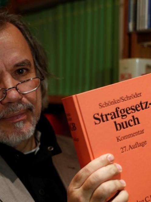 Rainer Pohlen, the lawyer for the former SS soldier, poses with an edition of Germany's Criminal...