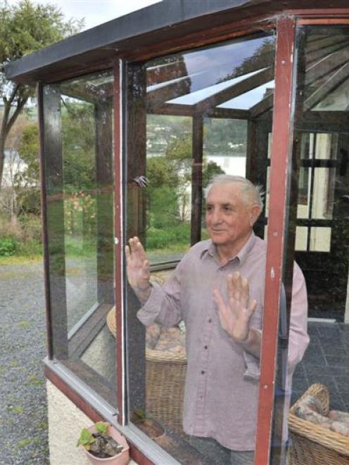 Ravensbourne resident Jim La Rooy looks out a self-cleaning glass window, which was installed by...