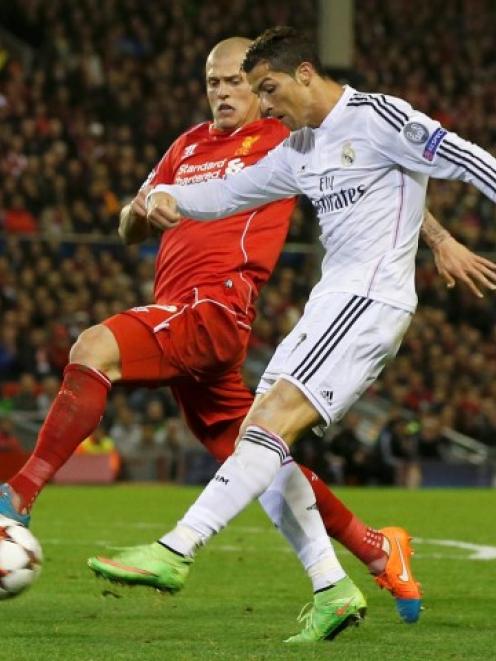 Real Madrid's Cristiano Ronaldo (R) shoots past Liverpool's Martin Skrtel during their Champions...