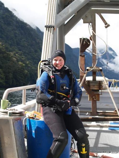 Rebecca McLeod in her drysuit before diving for samples in Fiordland. Behind her is a seafloor...