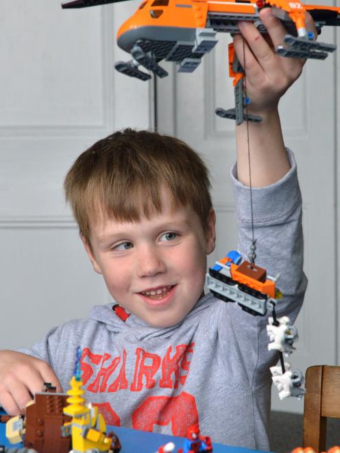 Micah Caldwell plays with Lego toys given to him after he was injured when a Noddy train...
