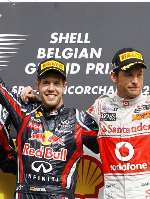 Red Bull driver Sebastian Vettel (C) of Germany celebrates on the podium with second-placed team...