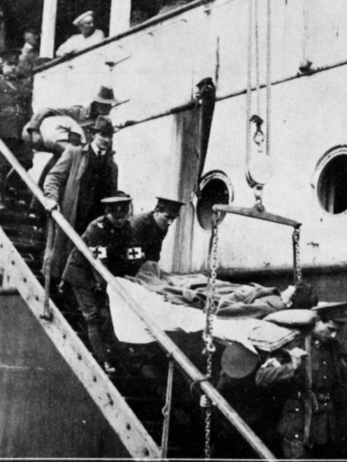 Red Cross men  bringing an invalided soldier down the gangway of the troopship Willochra at Port...