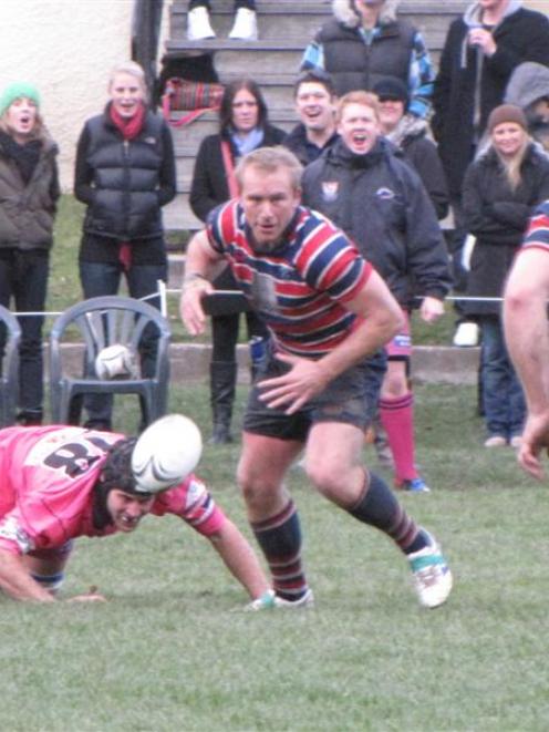 Reece Winter (centre), of Arrowtown, goes for the ball during the Battle of the Basin between...