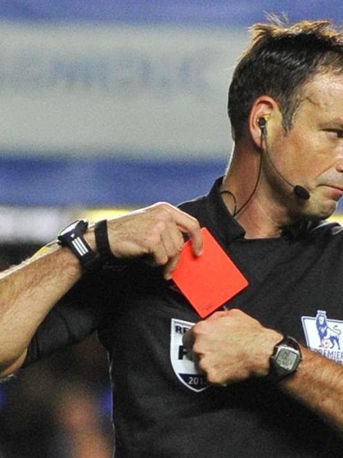 Referee Mark Clattenburg holds a red card after sending off Chelsea's Branislav Ivanovic during...