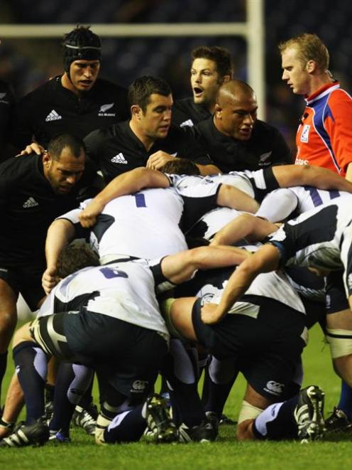 Referee Wayne Barnes presides over the setting of a scrum during the All Blacks' match against...